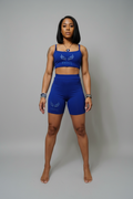 Black woman modeling blue Jinxs athletic set
