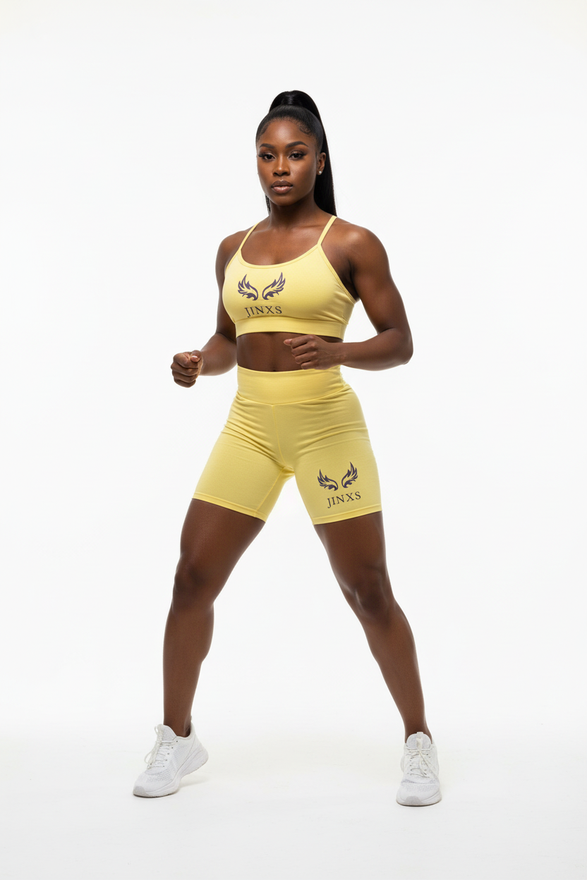 Black woman modeling yellow Jinxs athletic set